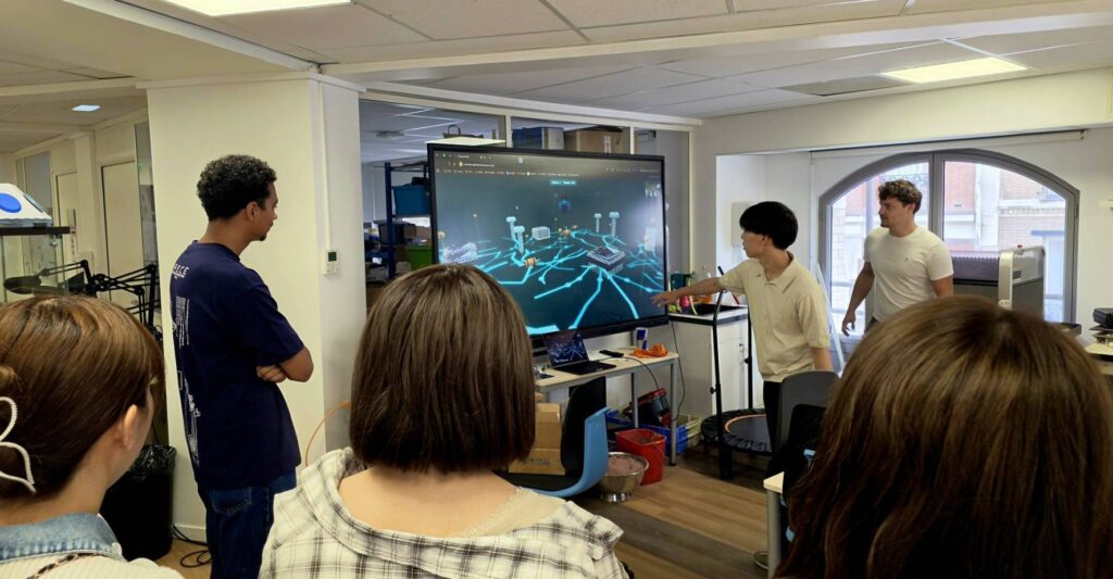 ラボの大型ディスプレイで回路のデモを見学する学生たち